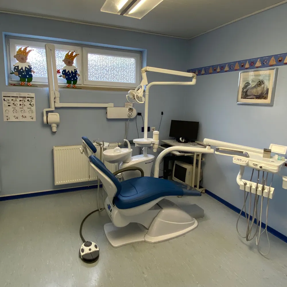 Behandlungszimmer mit blauem Behandlungsstuhl
